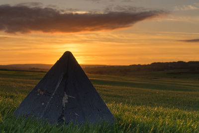 Empty country road along landscape at sunset
