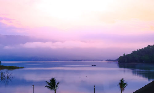 Scenic view of lake against sky at sunset