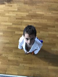Portrait of boy sitting on wooden floor