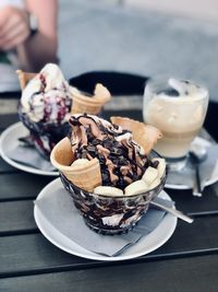 Midsection of person with ice cream in plate on table