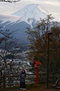 Rear view of man standing on snowcapped mountain