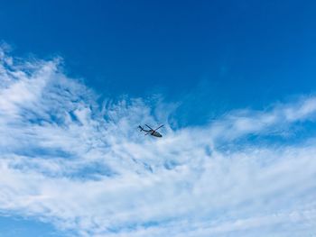 Low angle view of helicopter flying in sky