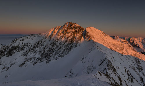 Scenic view of snowcapped mountains against clear sky during winter