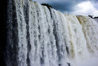 Close-up of frozen waterfall against sky