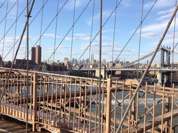 Bridges over river in city against sky