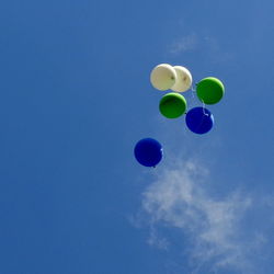 Low angle view of balloons against blue sky