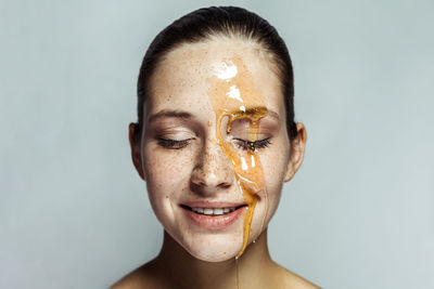 Close-up portrait of young woman against white background