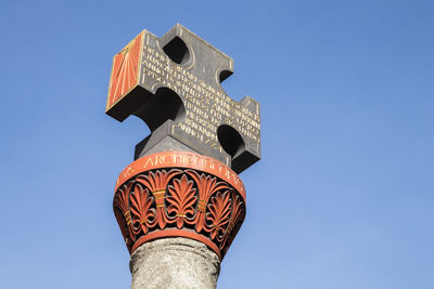 Low angle view of cross against clear blue sky