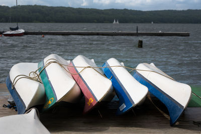 Boats moored in lake against sky