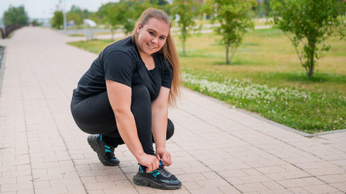 Portrait of smiling young woman on footpath