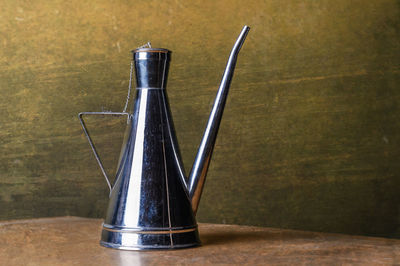 Close-up of old bottle on table against wall