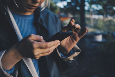 Midsection of man using mobile phone