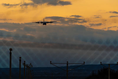 Low angle view of helicopter against sky during sunset
