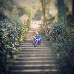 Rear view of woman walking on steps in forest