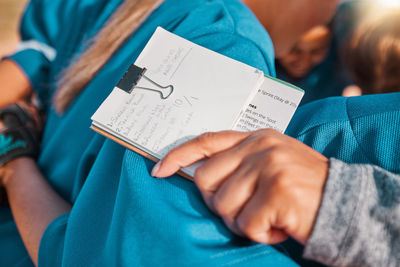 Midsection of man reading book