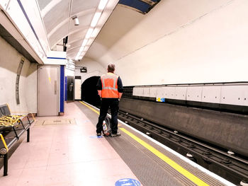 Rear view of man standing at railroad station