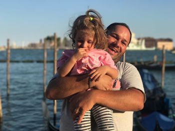Portrait of man holding daughter while standing against grand canal