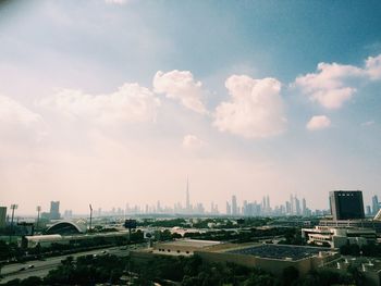 Buildings against cloudy sky on sunny day in city