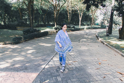 Portrait of woman on footpath in park