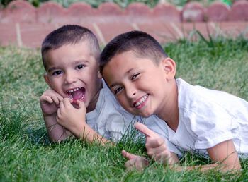 Laughing brothers lying in the grass