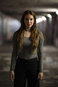 Portrait of young woman standing in tunnel