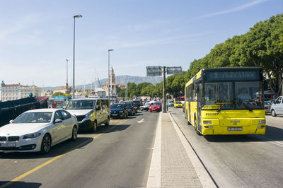 Cars on street in city against sky