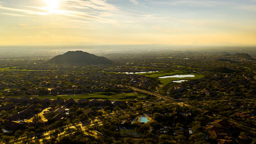 Aerial view of city against sky during sunset