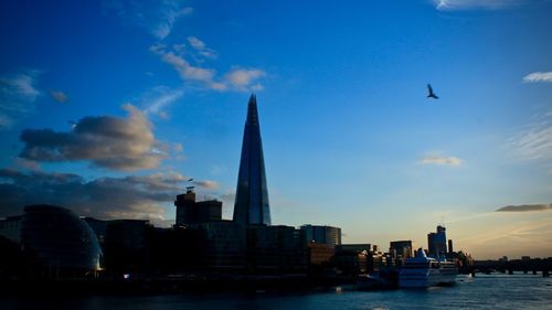 Buildings in city against cloudy sky