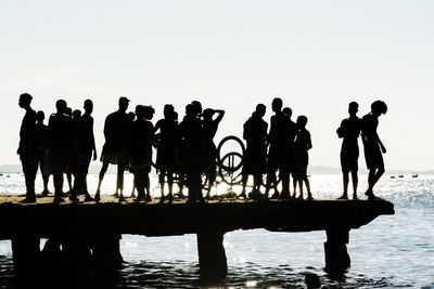 Dozens of young people, in silhouette, are seen during the sunset on top of the crush bridge 