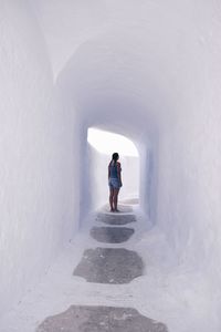 Rear view of woman standing in corridor