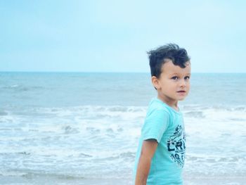 Side view of boy standing at beach