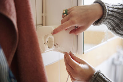 Hands plugging in charger