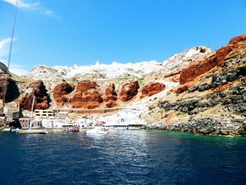 Scenic view of sea and mountains against blue sky