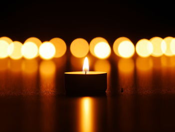 Illuminated tea light candle on table