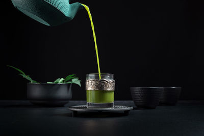 Close-up of tea cup on table against black background