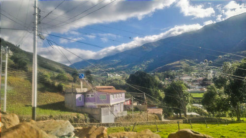 Houses by mountains against sky