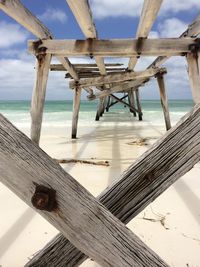 Pier on beach against sky