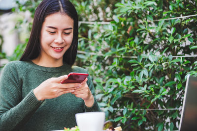 Young woman using mobile phone outdoors