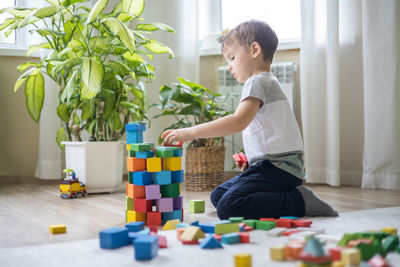 Side view of boy playing with toys at home