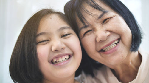 Close-up portrait of happy girl with grandmother