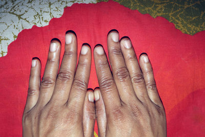 High angle view of woman hand over red background