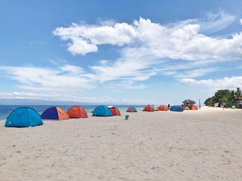 Multi colored tent on beach against sky