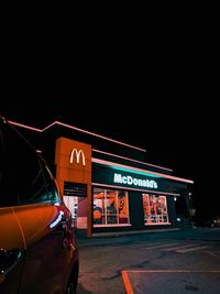 Information sign on road against sky at night