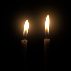 Close-up of lit candle in darkroom