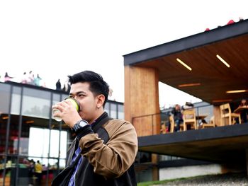 Young man drinking beer outdoors