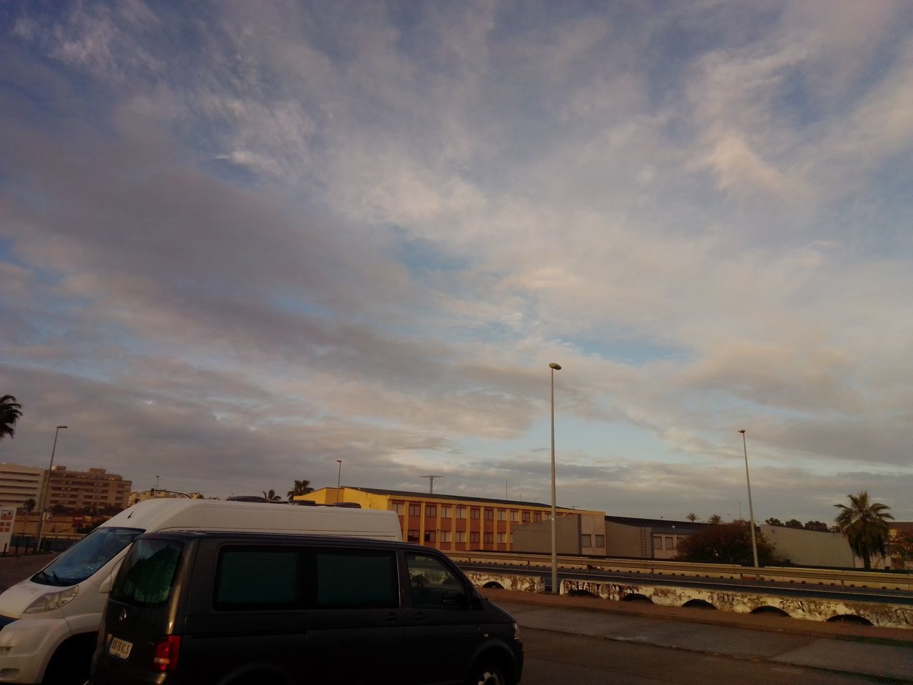 CARS ON ROAD IN CITY AGAINST SKY