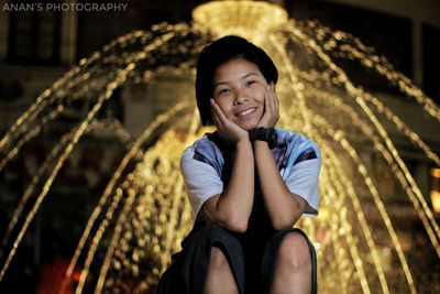 Portrait of smiling girl sitting outdoors