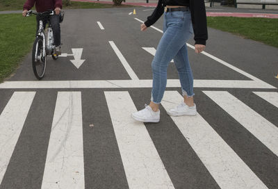 Low section of woman on zebra crossing on road