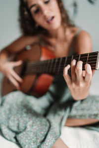 Midsection of woman playing guitar