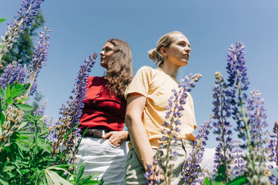 Portrait of two confident women under the hot summer sun on a field meadow.